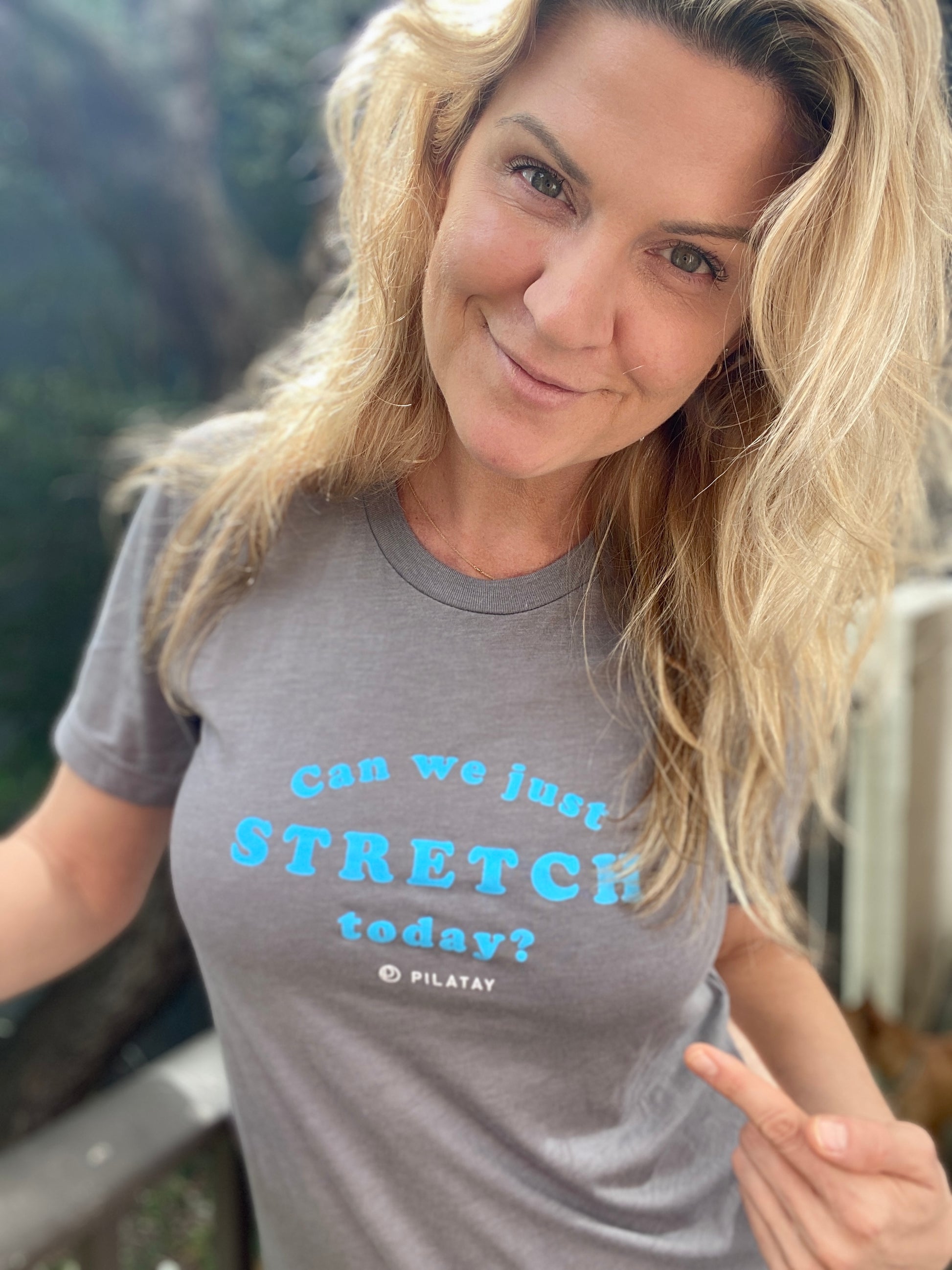 Pilates Shirt - A grey shirt with blue letters reading can we just stretch today worn by Tracy Belcher, owner of The Pilates Shop by PIlatay